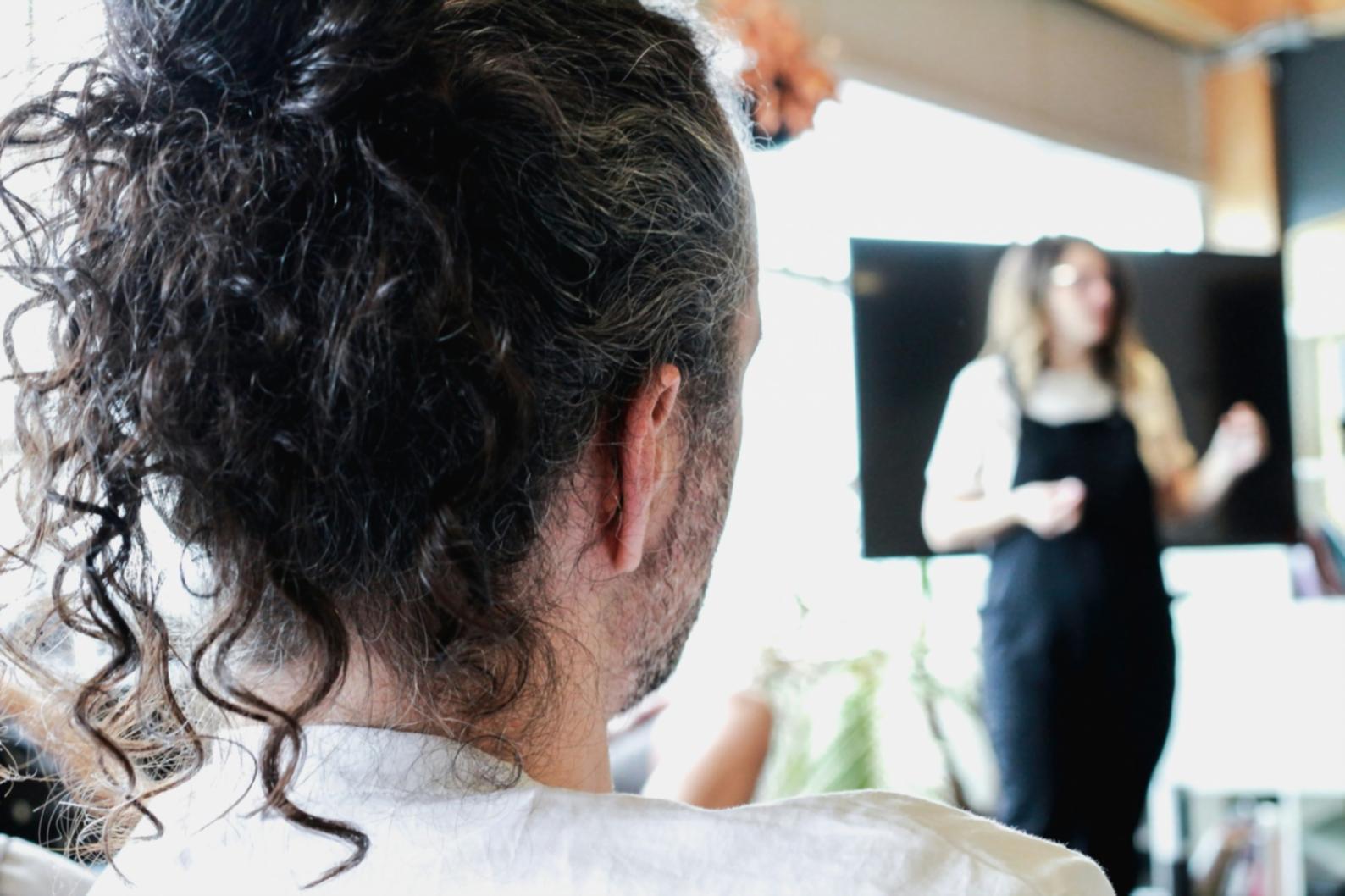 Student practicing advanced coloring techniques on a mannequin during hands-on training session